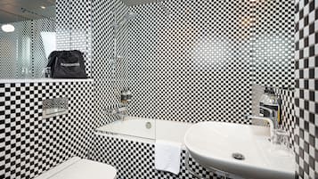 A bathroom with a checkered black and white tile pattern, a white sink, and a toilet.