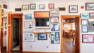 A hallway with framed pictures and a wooden door labeled "Telephone".