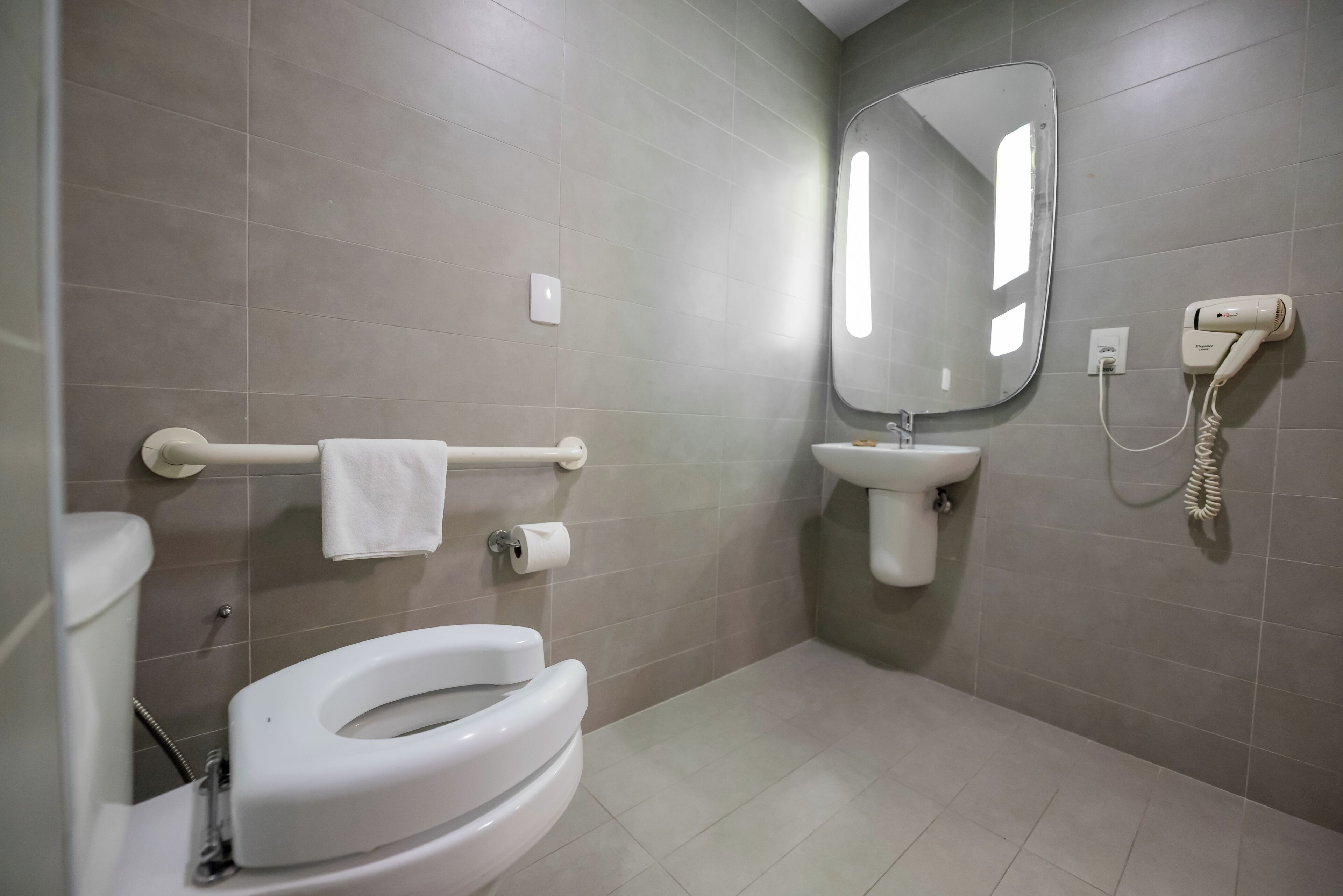 Un baño moderno con inodoro, bidé, lavamanos y espejo.