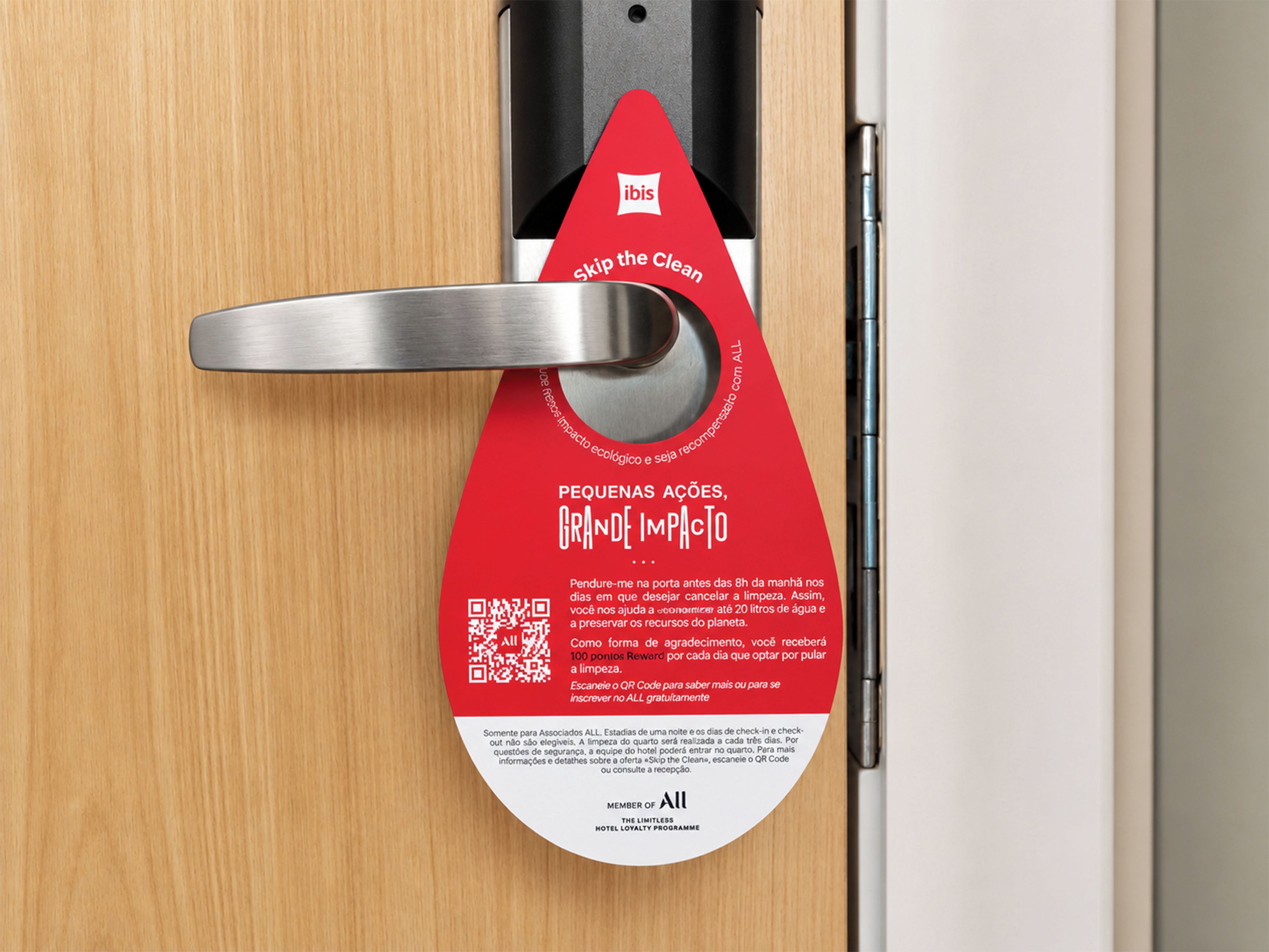 Puerta de hotel con una etiqueta roja en el pomo, promocionando una iniciativa de ahorro de agua.