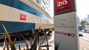 A hotel sign for ibis hotels, including the name 'ibis' and 'HOTELS' on a red background, and 'HOTEL IBIS FLORIANOPOLIS' on a white background.
