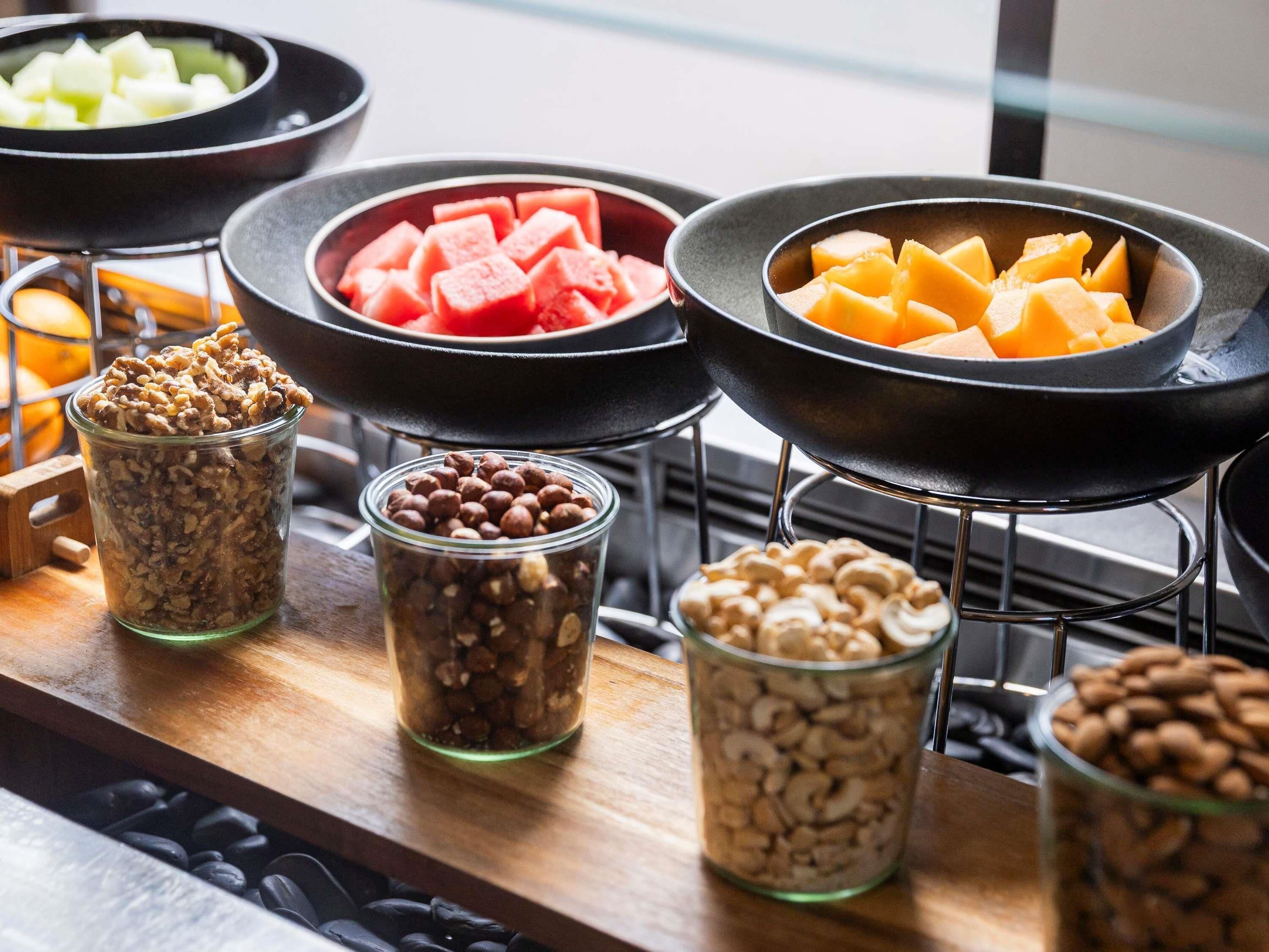 Buffet com diversos alimentos, incluindo nozes, frutas e queijo.