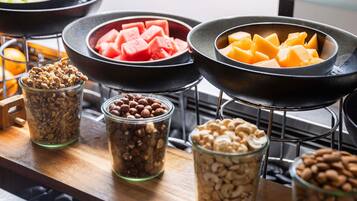 Buffet com diversos alimentos, incluindo nozes, frutas e queijo.