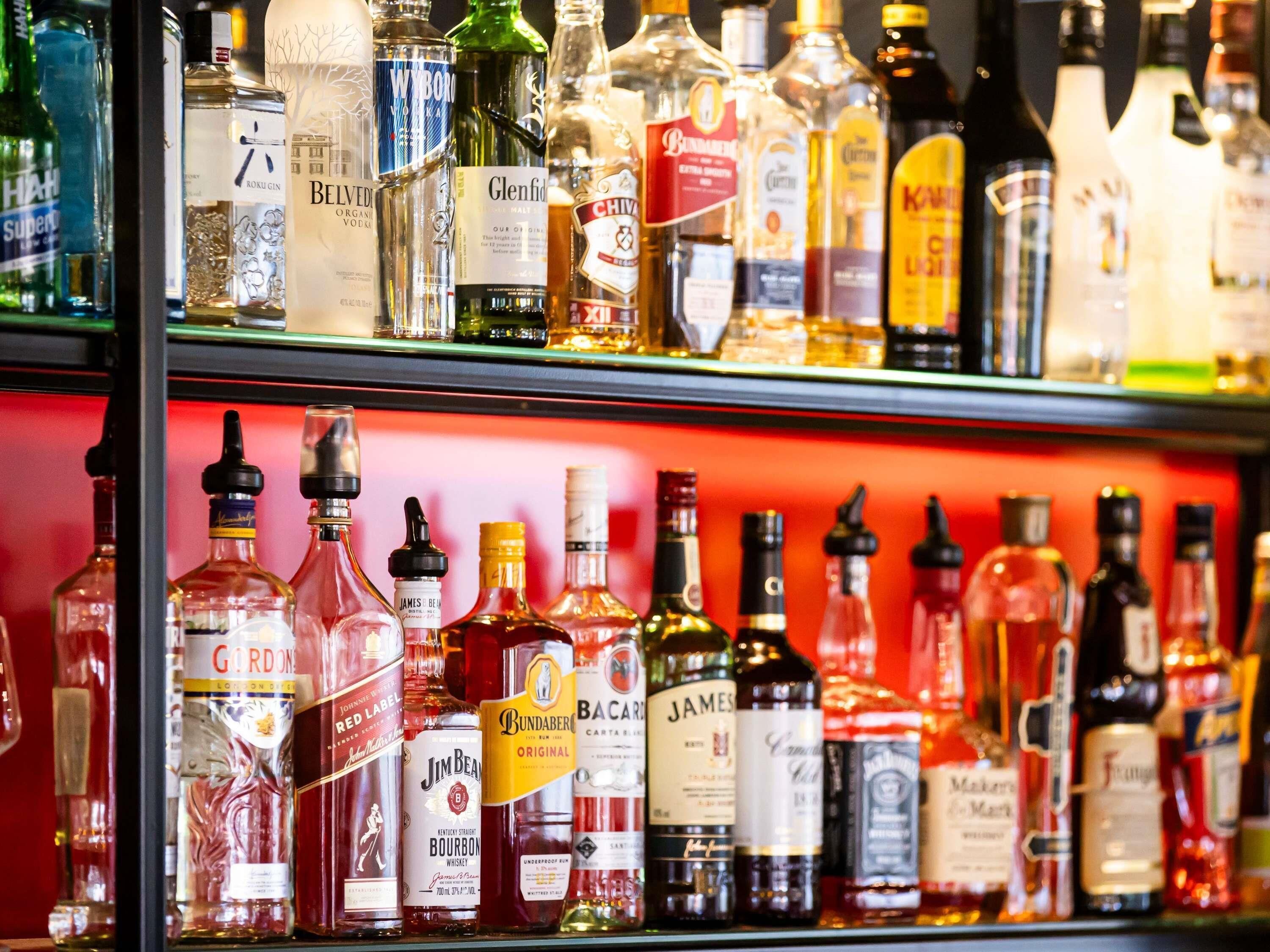 Diversas garrafas de bebidas alcoólicas em prateleiras.