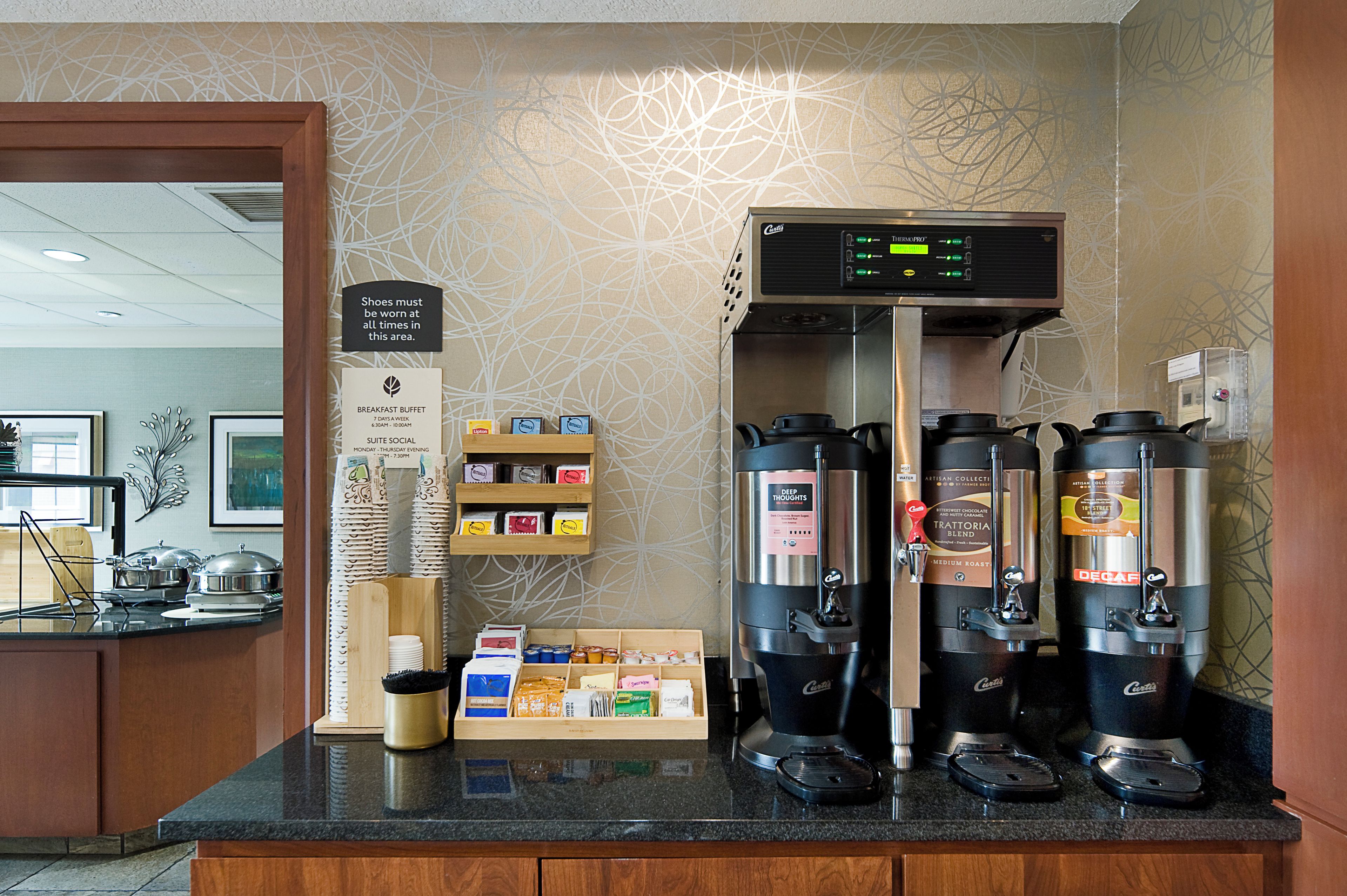 En kaffestation med en skylt som visar var frukostbuffén finns och vilka tider som gäller för sociala aktiviteter i sviterna.