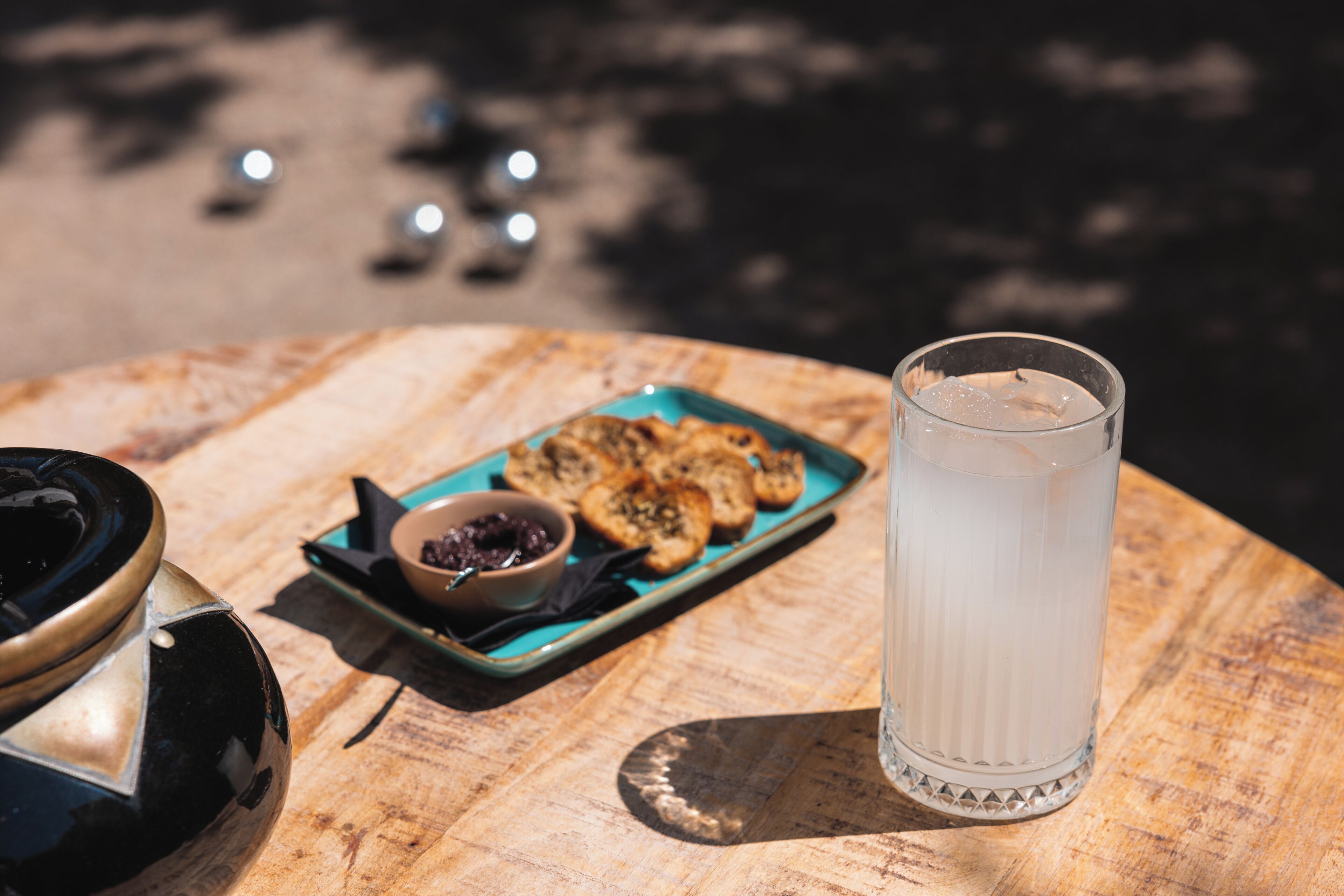 A table with a glass of water, a plate of cookies, and a bowl of jam.