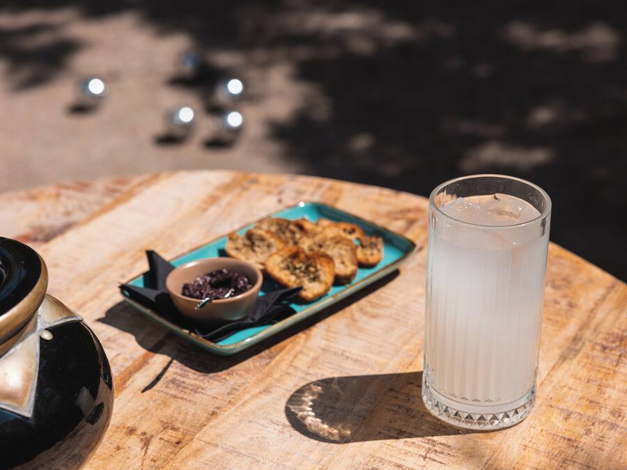 A table with a glass of water, a plate of cookies, and a bowl of jam.