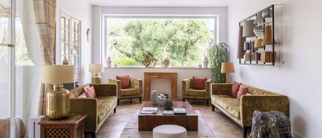 A living room with a fireplace, two sofas, a coffee table, and a decorative elephant statue.