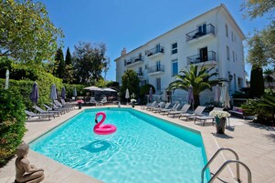 Een buitenzwembad, parasols voor strand/zwembad
