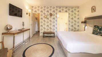 A hotel room with a bed, bedside table, lamp, and a round rug.