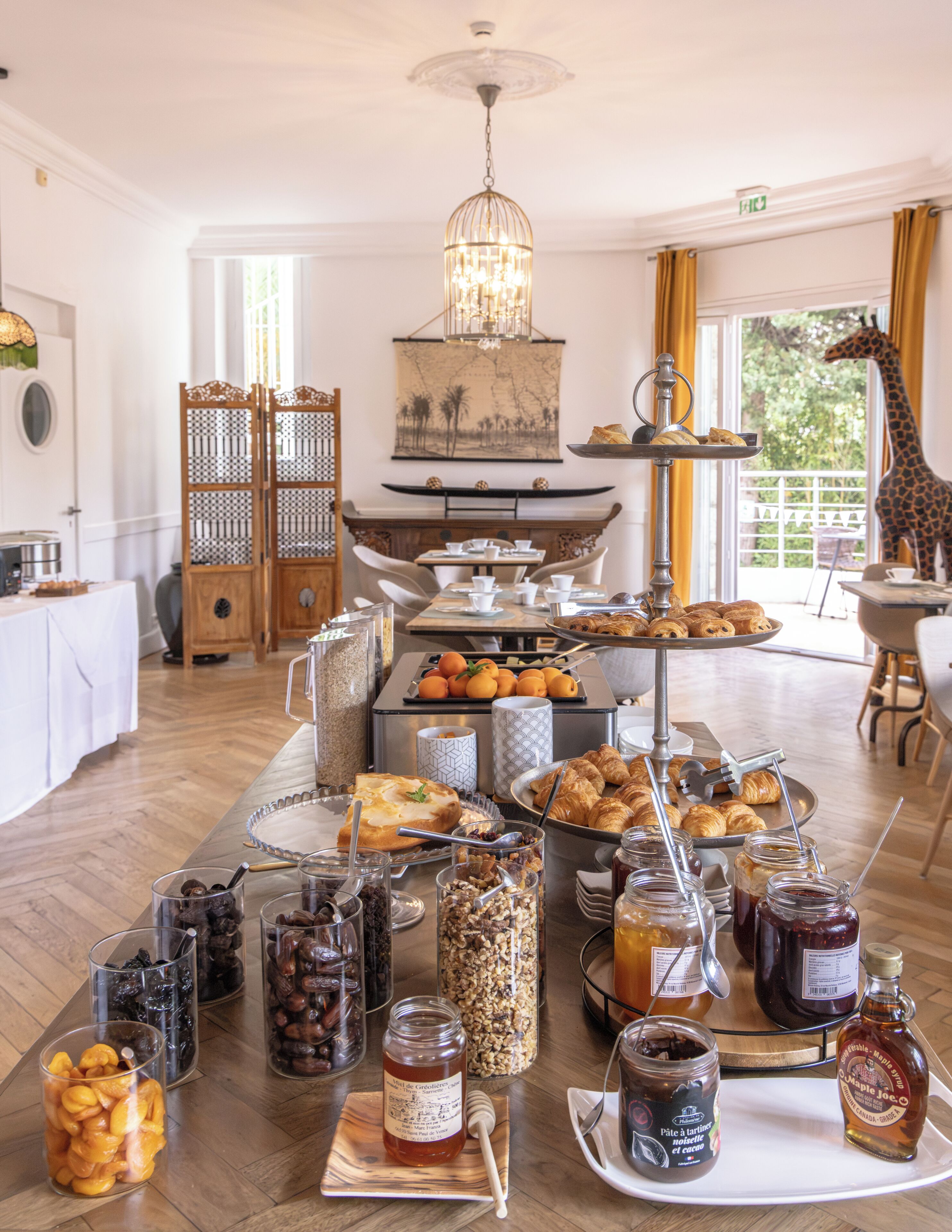 Ein Frühstücksbuffet mit verschiedenen Speisen, einem Kronleuchter und einer Giraffestatue.