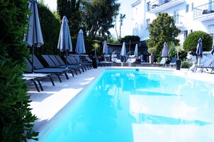 Een buitenzwembad, parasols voor strand/zwembad