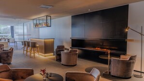 Un'area lounge moderna con divani, un camino e un bar.