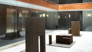 Un edificio moderno con diversi piani in vetro, pannelli di legno e arredamento minimalista.