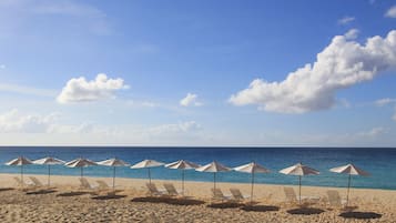 På stranden, hvit sand, solsenger og parasoller