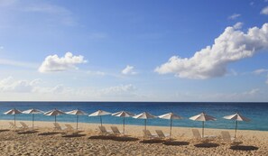 On the beach, white sand, sun loungers, beach umbrellas