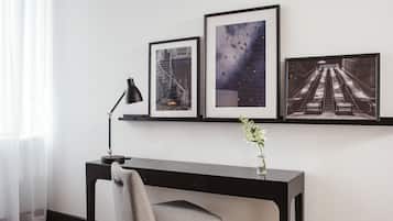 Un espace de bureau moderne comprenant un bureau, une chaise et trois tableaux encadrés accrochés au mur.