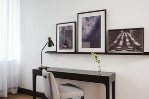 Un espace de bureau moderne comprenant un bureau, une chaise et trois tableaux encadrés accrochés au mur.