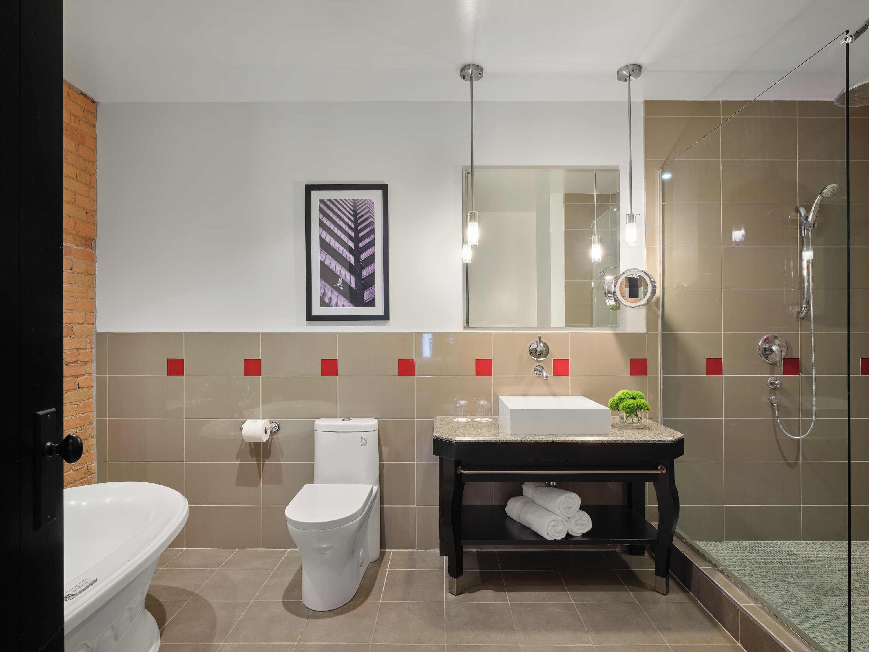 Ein modernes Badezimmer mit Toilette, Waschbecken und Dusche.