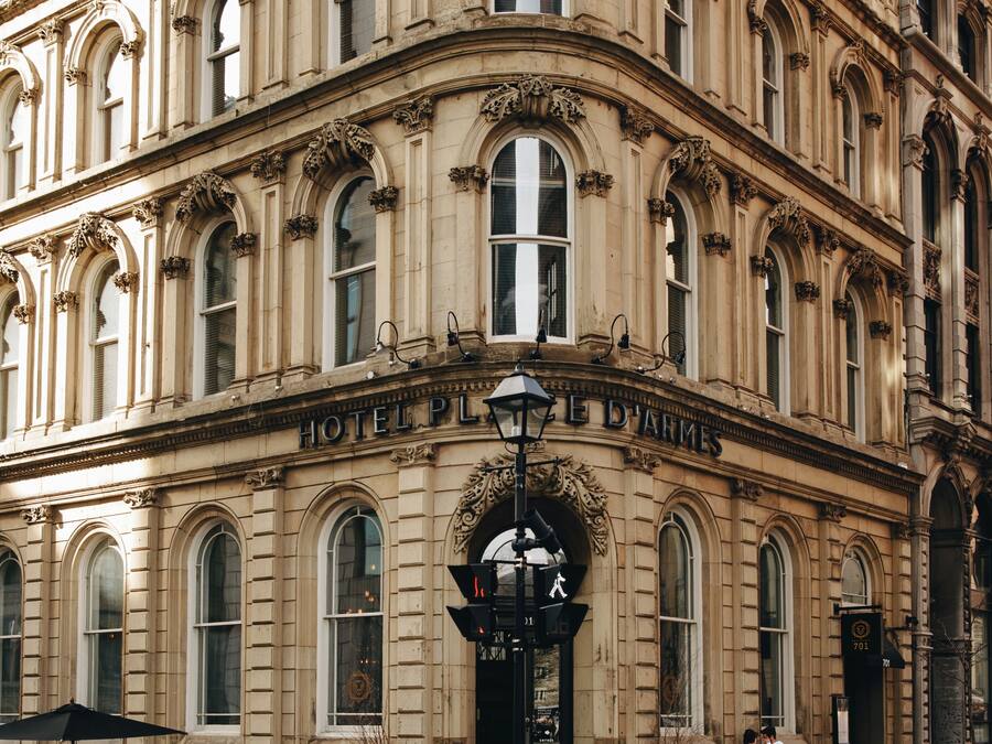 A historic building with ornate architecture, a prominent entrance, and a sign reading "HOTEL DE L'AMER."