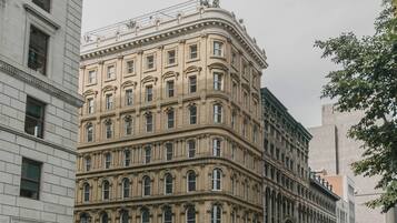 Un bâtiment historique à étages, doté de grandes fenêtres et d’une entrée d’angle remarquable.