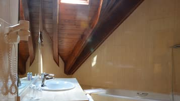 Een badkamer met een houten plafond, een wastafel en een bad.