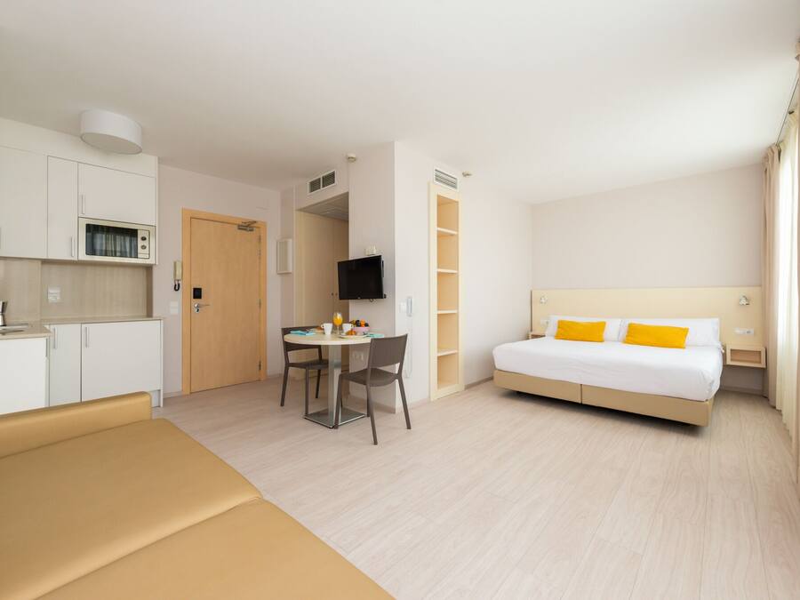 Une chambre d’hôtel comprenant un lit, un canapé, une table à manger et une kitchenette.