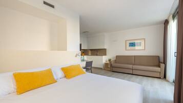 Een hotelkamer met een bed, een bank, een bureau en een kitchenette.