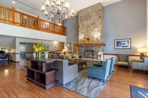 A spacious lobby with a fireplace, comfortable seating, a reception desk, and a staircase. - Best Western Plus Edmonds Harbor Inn (Edmonds)