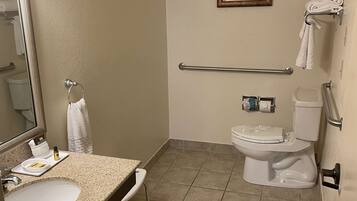 A bathroom with a sink, mirror, toilet, and towel rack.