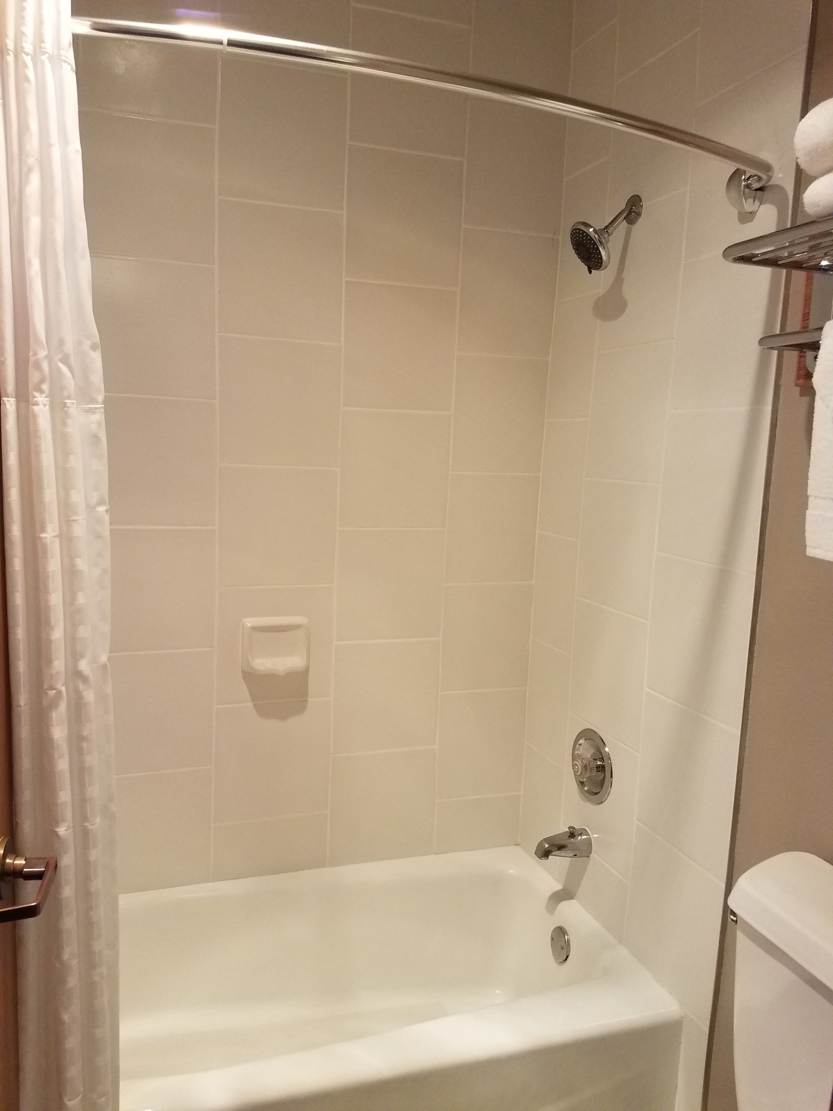 A bathroom with a bathtub, shower, and toilet.