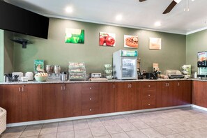 A kitchen area with a counter, a refrigerator, and various food items. - Quality Inn & Suites Bainbridge Island (Bainbridge Island)