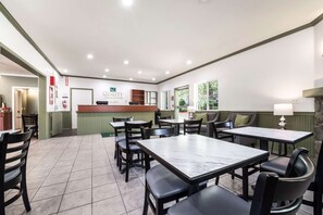 A restaurant with a reception desk, multiple tables, and chairs. - Quality Inn & Suites Bainbridge Island (Bainbridge Island)