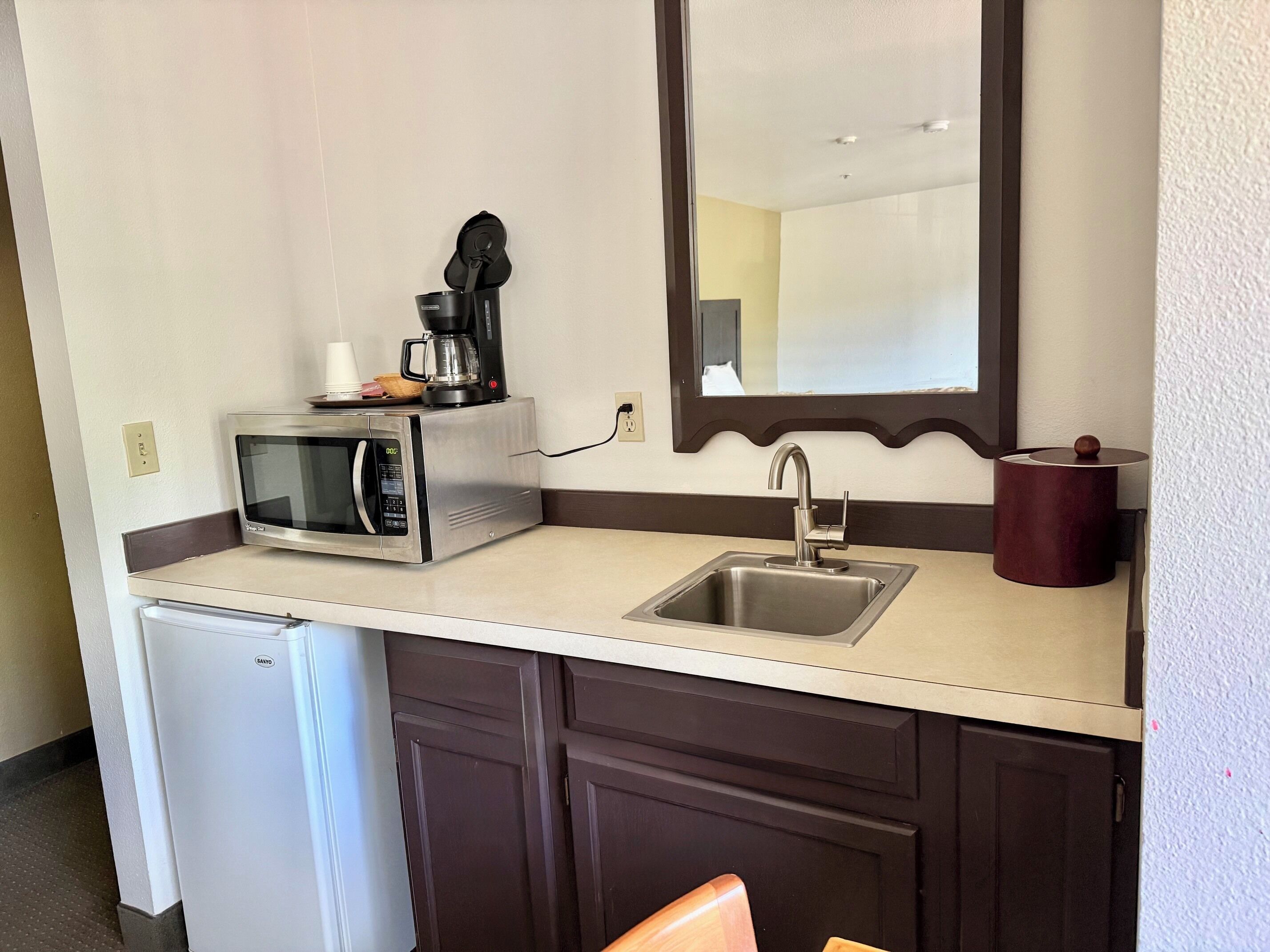 Una kitchenette equipada con microondas, cafetera y pileta.