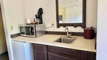 Una kitchenette equipada con microondas, cafetera y pileta.