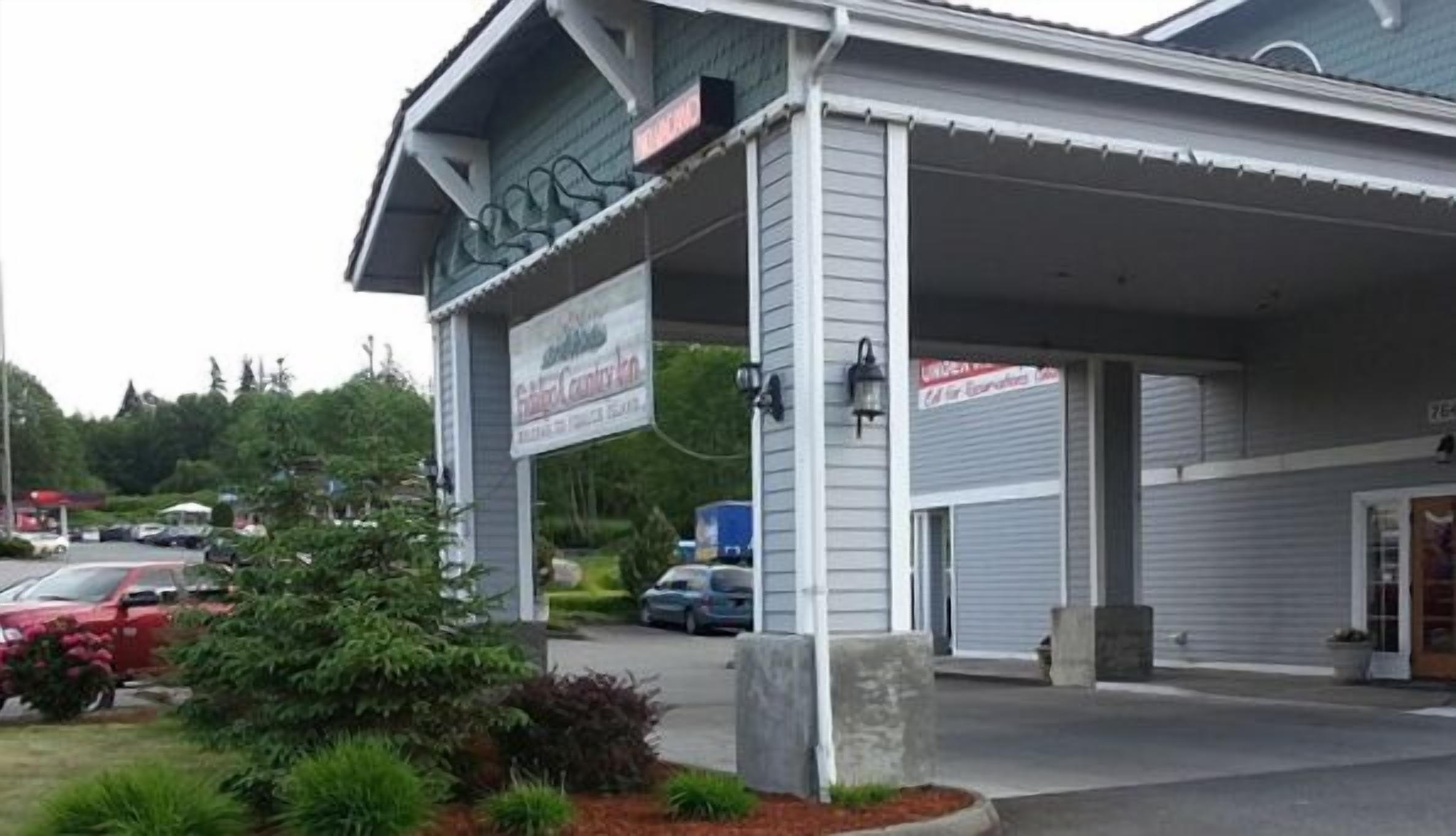 A building with a covered entrance and a sign for a business.