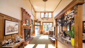A spacious lobby with a fireplace, a chandelier, and a staircase with ornate railings. - Fairhaven Village Inn (Bellingham)