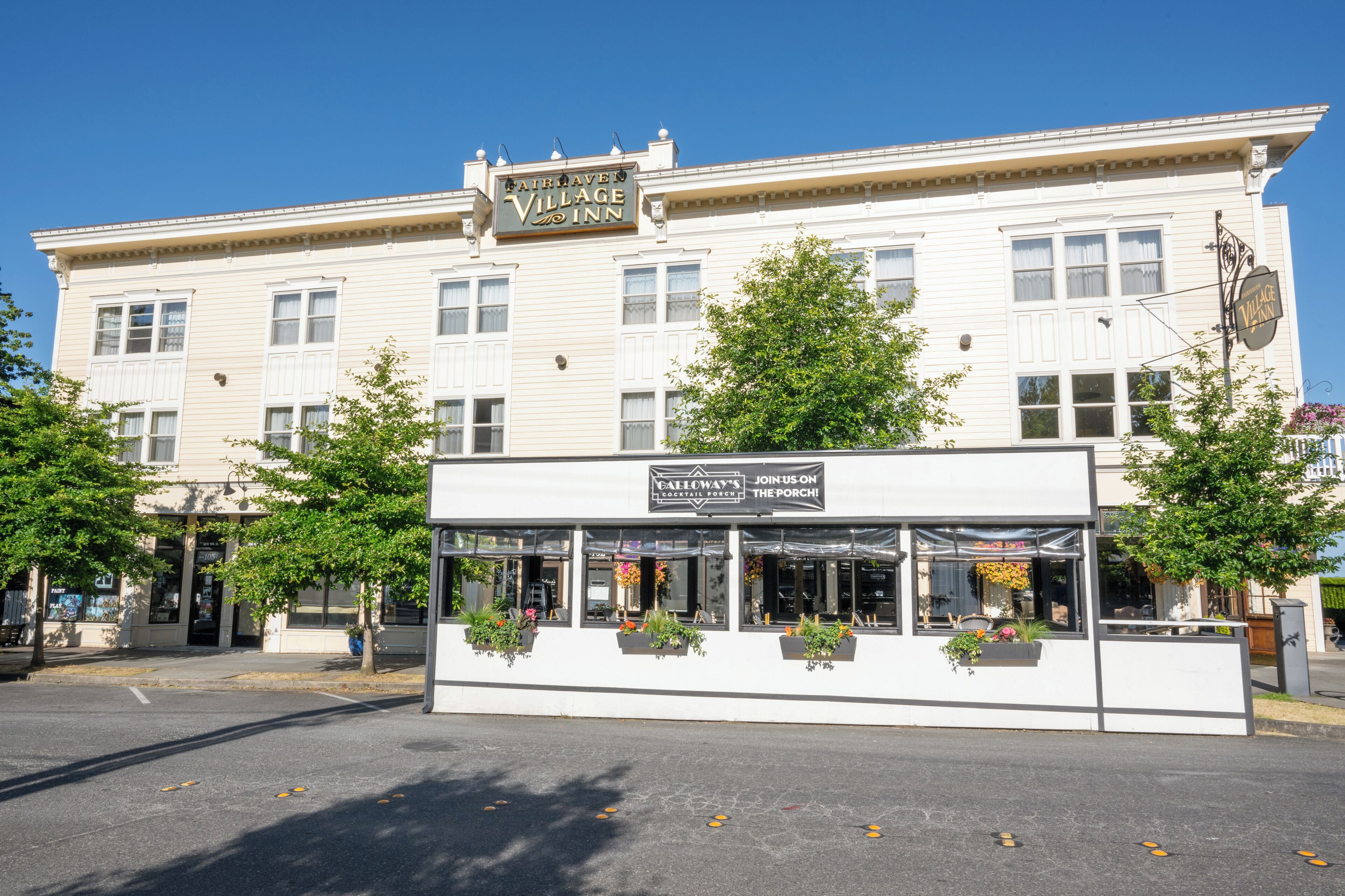 A building with a sign for 'Fairway Village Inn' and a smaller sign for 'Join Us on the Porch' cafe.
