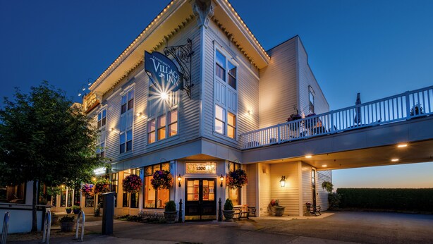 A two-story building with a balcony and a sign reading "Village Inn." - Fairhaven Village Inn (Bellingham)