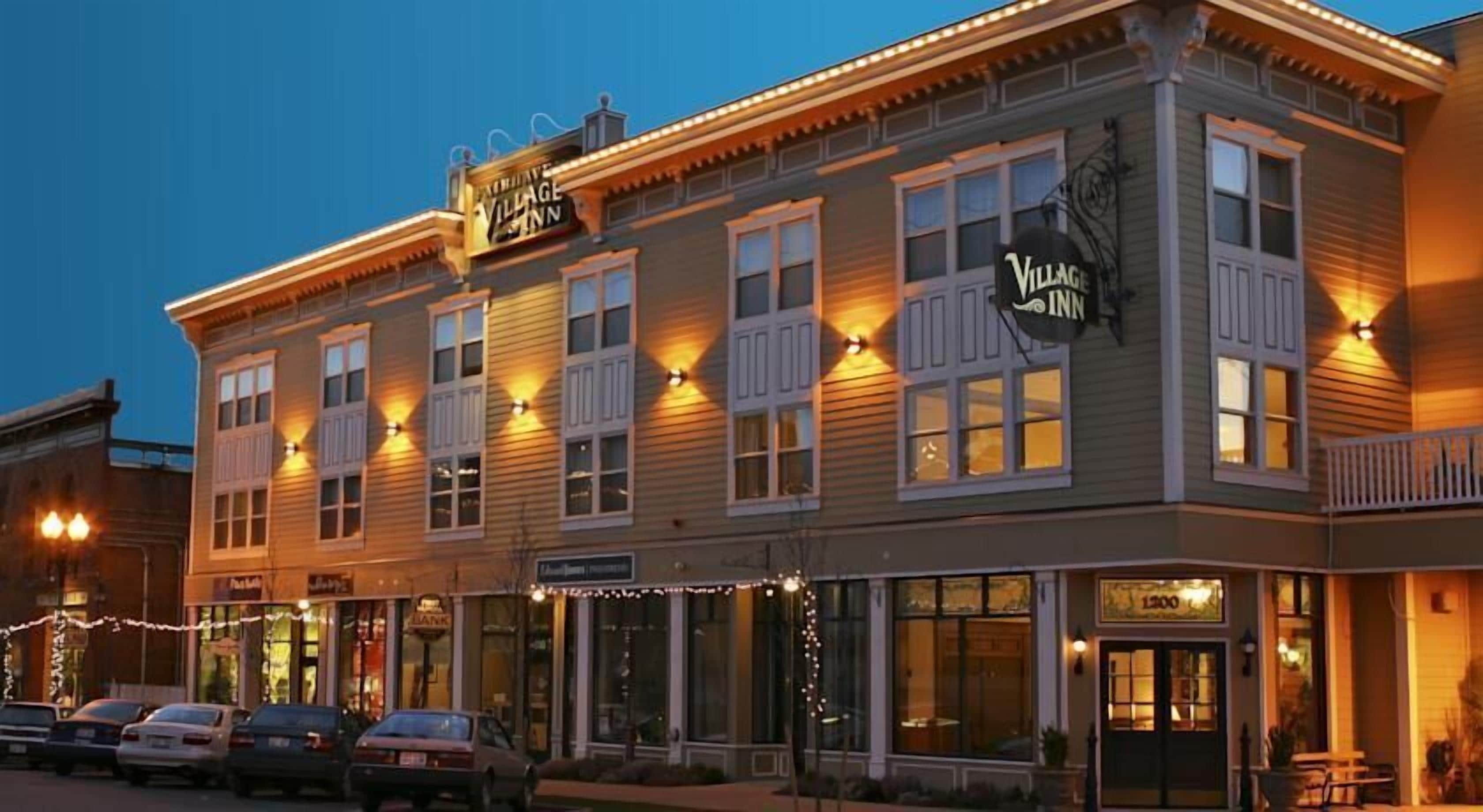 Un edificio de dos pisos con un letrero que dice 'Village Inn'.
