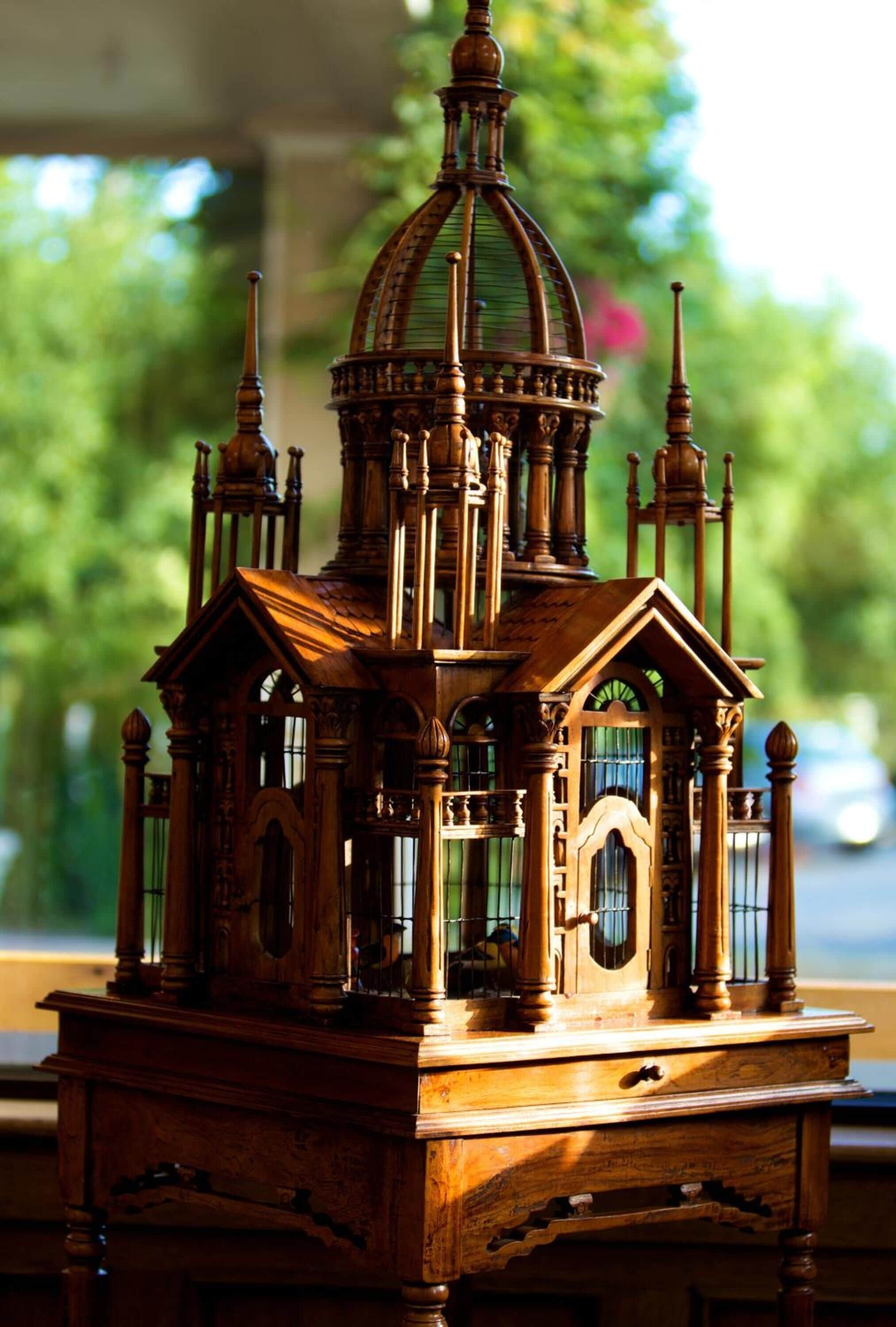 A detailed wooden model of a church with multiple spires and a dome, placed on a table.