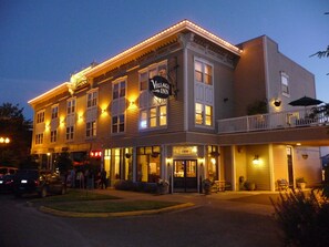 A two-story building with a sign reading "Village Inn." It features a balcony with outdoor seating and a large entrance door.