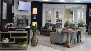 Una sala de estar moderna con chimenea, televisor y un ventanal grande.