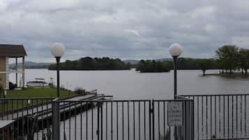 A waterfront view with a no alcohol beverages allowed sign, a dock, and a building with a covered area.