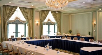 A conference room with a long table, chairs, and a chandelier.