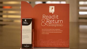 A promotional display for a Read it & Return Lending Library, featuring a book and a box with information.