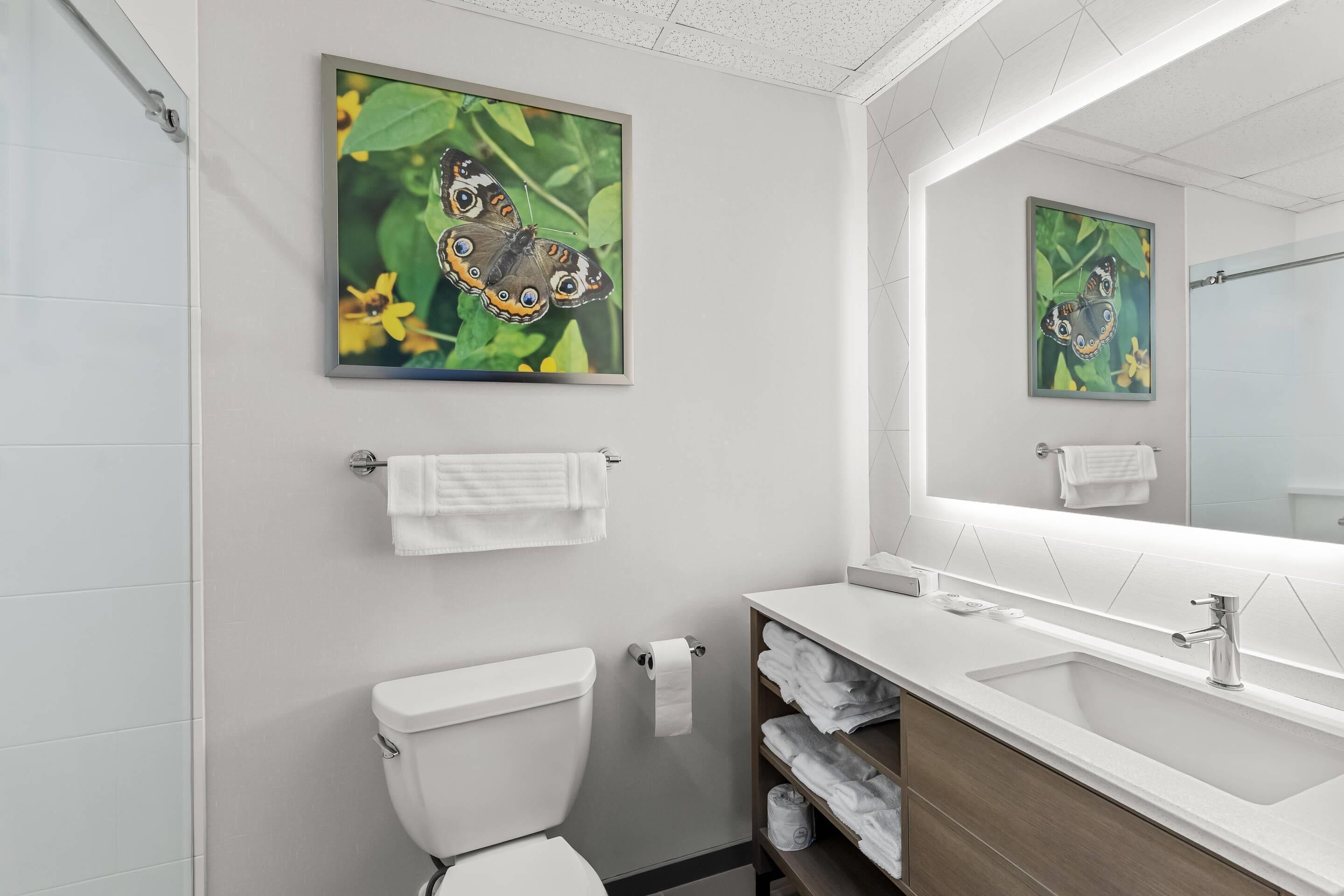 A modern bathroom with a toilet, sink, and towel rack.