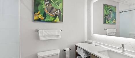 A modern bathroom with a toilet, sink, and towel rack.