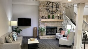 A living room with a fireplace, a sofa, a coffee table, and a television.