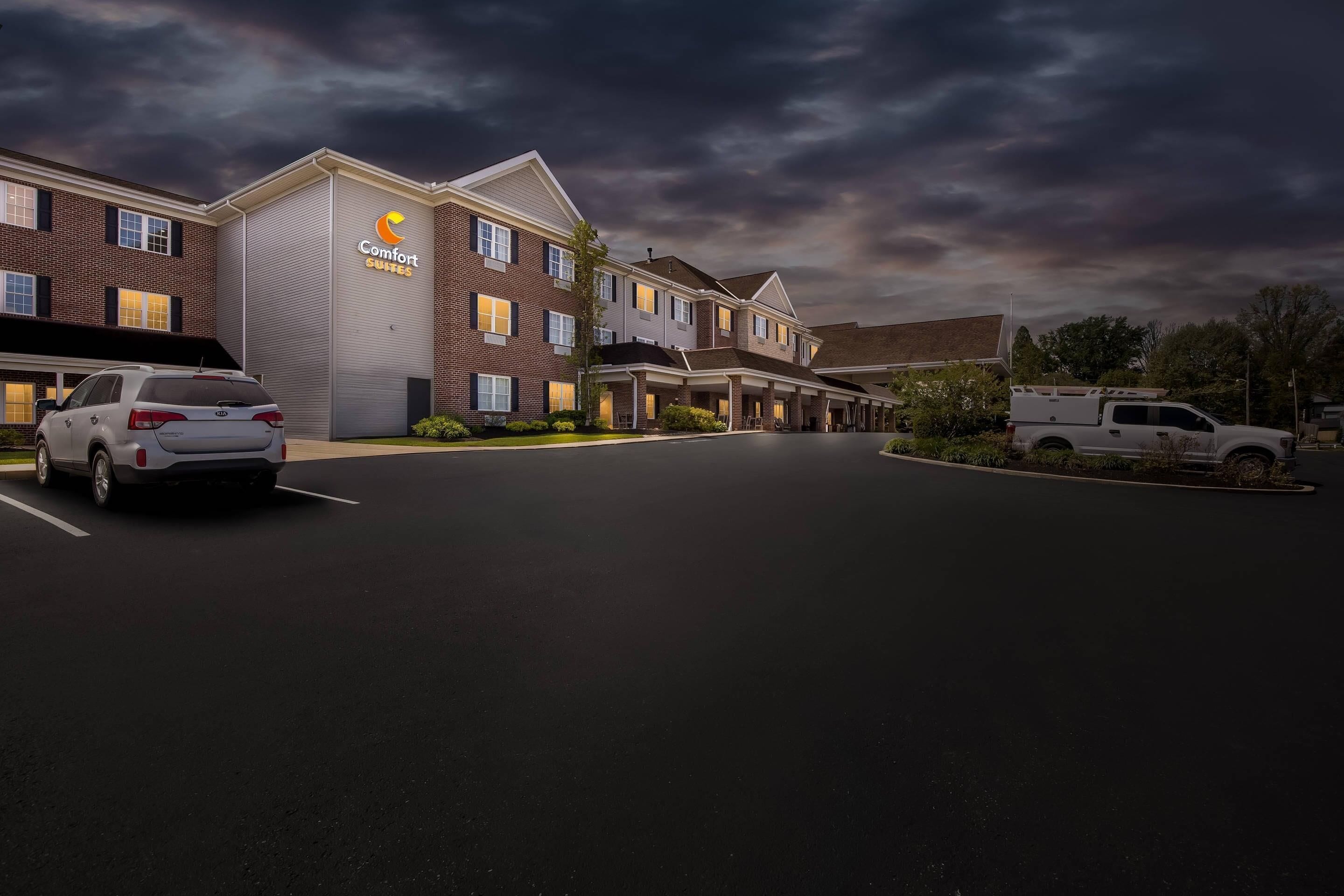 A hotel with a brick facade, a covered parking area, and a truck parked outside.